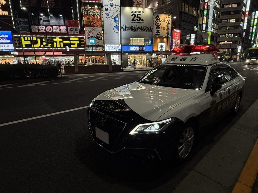 夜の繁華街に停車しているパトカー